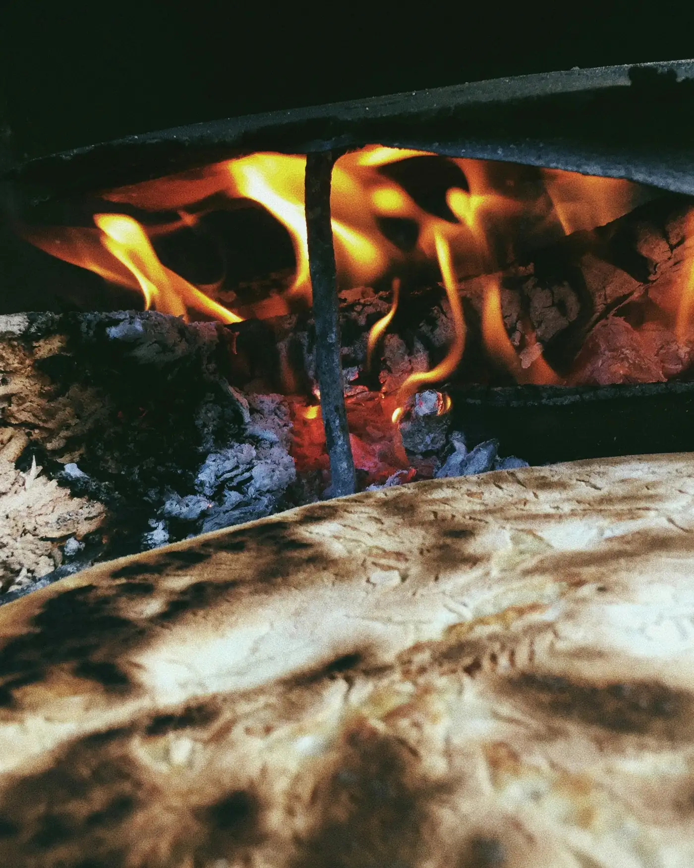 A base blistering on the hearth stone with flames curling above it
